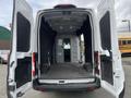 Rear view of a 2023 Ford Transit with open double doors revealing the cargo area and front cabin