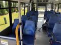 Interior view of a 2020 Chevrolet Express bus featuring blue seats in a layout with handrails and safety signage