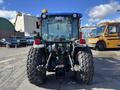 A 2010 New Holland T4050 tractor featuring large rear tires a blue hood and a visible rear hitch and hydraulic connections