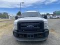 A 2014 Ford F-350 SD with a white exterior and black front grille is parked facing forward with its headlights visible