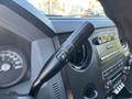 Close-up view of the control stalk for a 2011 Ford F-550 featuring a +/- switch for additional control settings and dashboard elements visible in the background