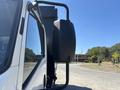 A 2016 Isuzu NPR-HD truck viewed from the side showing the side mirror and part of the cab