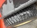 Close-up of a tire from a 2010 Kubota F3680 showcasing a deep tread pattern with water droplets on the surface