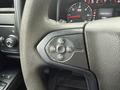 Close-up of the steering wheel control panel in a 2015 GMC Sierra 1500 featuring buttons for cruise control settings and adjustments