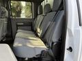 A 2015 Ford F-550 with a spacious interior featuring gray fabric seats and seatbelts in a crew cab layout