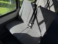 Two gray cloth seats with seat belts inside a vehicle, designed for passenger seating, with a simple and functional layout
