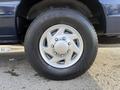 A close-up view of a wheel and tire from a 2011 Ford Econoline showcasing a silver alloy rim and black tire tread