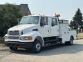 A white 2006 Sterling Acterra truck with dual cab and utility bed featuring orange lights on top and side compartments for storage