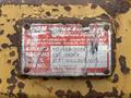 A rusty metal identification plate from a 2012 Caterpillar 980 featuring details like assembly number model and serial number