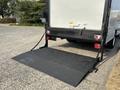 A black loading ramp lowered from the back of a 2008 Ford Econoline, showing a flat surface for easy access to the cargo area