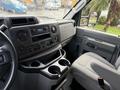 Interior view of a 2022 Ford E-450 showing the dashboard console and driver's seat with controls and storage compartments