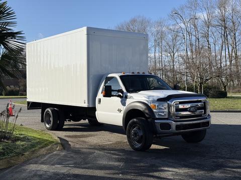 A white 2010 Ford F-450 box truck with a large cargo area and black wheels positioned at an angle