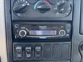 A Panasonic car stereo with digital display and control knobs mounted in a dashboard panel featuring buttons for various functions