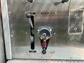 A control panel for a 1999 Freightliner FL80 featuring a lever labeled for suction operation and a circular valve with an attached cord