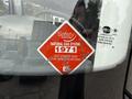 A red warning sticker on a glass surface features the words Safety Authority and Natural Gas System along with the number 1971 and instructions to see the other side for specifications