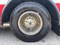 Close-up of a tire and wheel assembly on a 1999 Freightliner FL80 showcasing the chrome rim and tread pattern on the tire