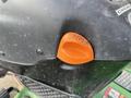 A close-up of the control panel of a 2021 John Deere L Series (S) featuring an orange lever with a parking symbol and various labels for operation