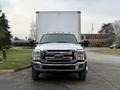 A white 2012 Ford F-550 truck with a boxy cargo area and prominent front grille facing forward