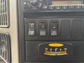 The image shows the dashboard controls of a 2013 International DuraStar 4300 featuring various switches and a gauge for monitoring settings and functions