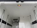 The interior of a 2020 RAM Promaster with a smooth white ceiling and a ceiling light visible along with metal rails for securing cargo