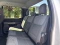 Interior view of a 2021 Ford F-150 showing the backseat with gray fabric upholstery and seatbelts