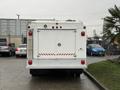A white 2014 International TerraStar truck with a boxy rear design and red reflective stripes on the back doors
