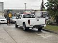 A white 2011 Chevrolet Colorado parked with its tailgate down showcasing its truck bed and rear design