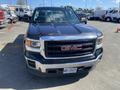 A black 2014 GMC Sierra 1500 truck facing directly toward the viewer with a prominent chrome grille featuring the GMC logo and sleek headlights