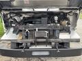 2012 Ford E-450 Super Duty with its rear engine compartment visible showing various mechanical components and wiring