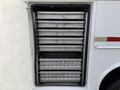 A compartment with multiple stacked metal trays inside a 2010 Ford F-550 vehicle