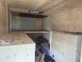 Interior view of a 2009 Workhorse W62 with wooden walls and flooring showing shelves and construction materials scattered on the floor