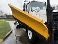 A yellow snow plow attached to a 2016 Freightliner 108SD truck