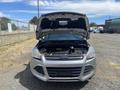 A 2015 Ford Escape in silver with the hood raised revealing the engine compartment