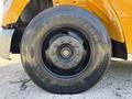 Close-up of a black tire from a 2011 Freightliner B2 featuring the Goodyear brand name and a rim with multiple bolts