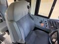Driver's seat of a 2013 International CE300 school bus with a high back and seatbelt visible alongside the control panel and dashboard