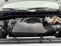 The engine compartment of a 2019 Chevrolet Silverado 1500 featuring a large engine cover and various components including hoses and fluid reservoirs