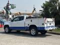 2017 Chevrolet Colorado with a white body and blue accents featuring a utility bed and tool compartments on the rear