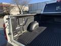 A 2023 RAM 3500 truck bed featuring a black textured liner with a wheel well cover and storage compartments
