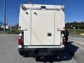 A 2016 Ford F-250 SD with a white cargo body and a closed rear door is shown from the back with taillights visible and no markings on the surface