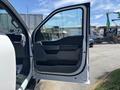 A 2021 Ford F-150 with the driver's side door open showing the interior door panel and handle