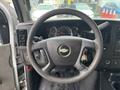 Steering wheel and dashboard of a 2018 Chevrolet Express featuring gauges controls and a key in the ignition