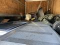 A 2014 Hino 195 truck's cargo area filled with various discarded items including a chair a tarp and a toilet seat