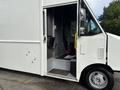 A 2018 Ford Econoline van with an open side door showing the driver's seat and interior details