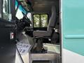 Interior view of a 2020 Freightliner MT45 showing the driver's seat and control panel with a simple gray fabric seat and metallic floor surface