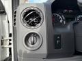 A close-up of the dashboard of a 2013 Ford Econoline showing air vents a headlight control knob and a switch for interior lights