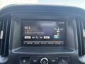 A close-up view of a Chevrolet Colorado dashboard featuring a touchscreen display showing a radio station and song information