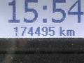A digital display showing the time as 15:54 and the odometer reading 174495 km