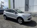 A silver 2014 Ford Escape parked with a side view showcasing its sleek design and alloy wheels