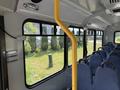Interior view of a 2017 Chevrolet Express with blue fabric seats and a yellow pole support along the aisle