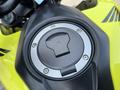 Close-up of the fuel cap on a bright yellow 2018 Honda Grom motorcycle with a sleek design and a circular metal cap in the center